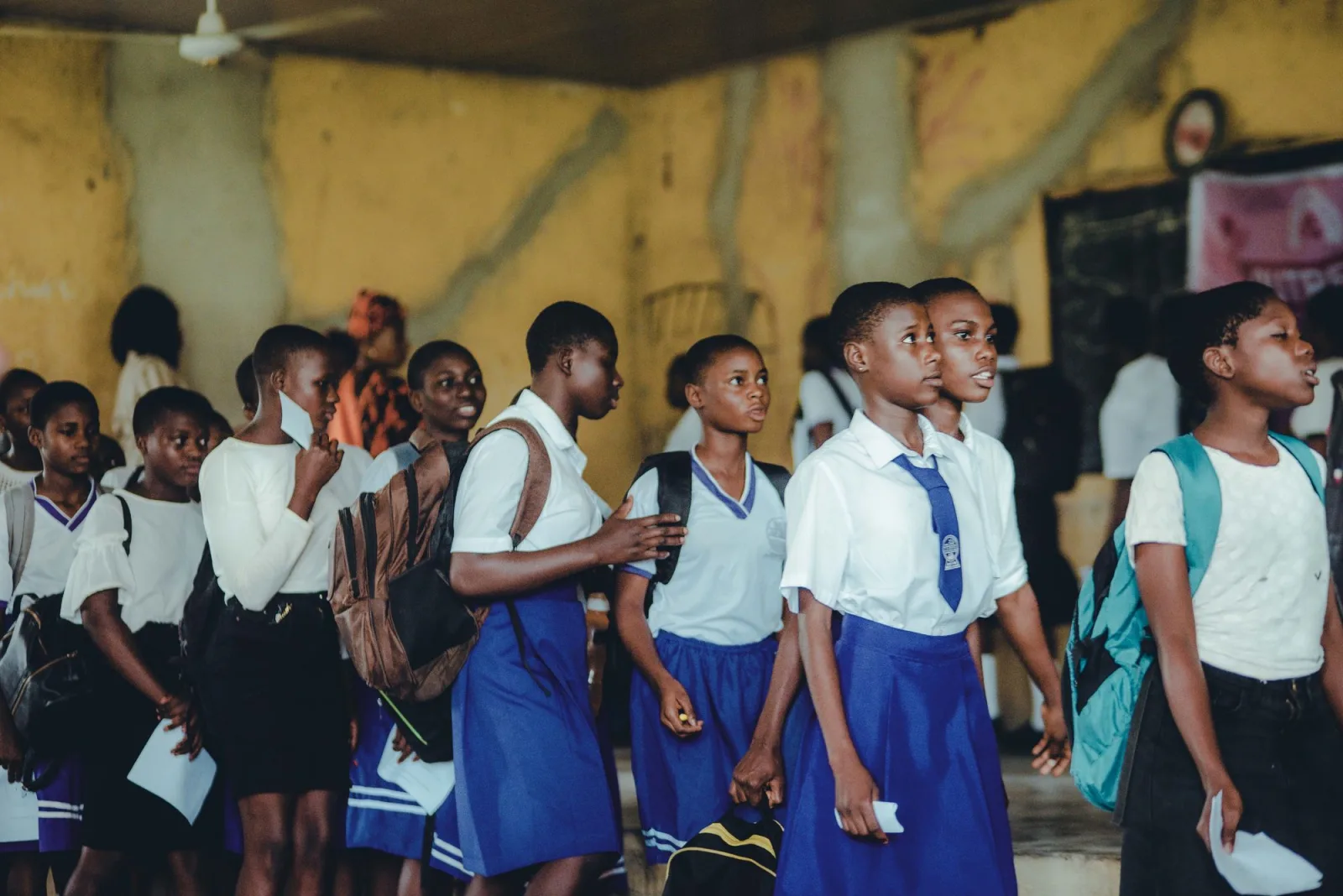 Secondary school girls in blue and white uniform walking together. Photo by Tosin Olowoleni on Pexels.